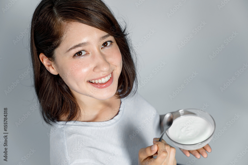 young woman eating yogurt on blue background. Intestinal flora. young woman eating yogurt on blue background. Intestinal flora.