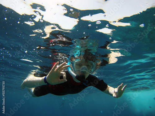  Boy under the water in a mask with a tube in a wet suit