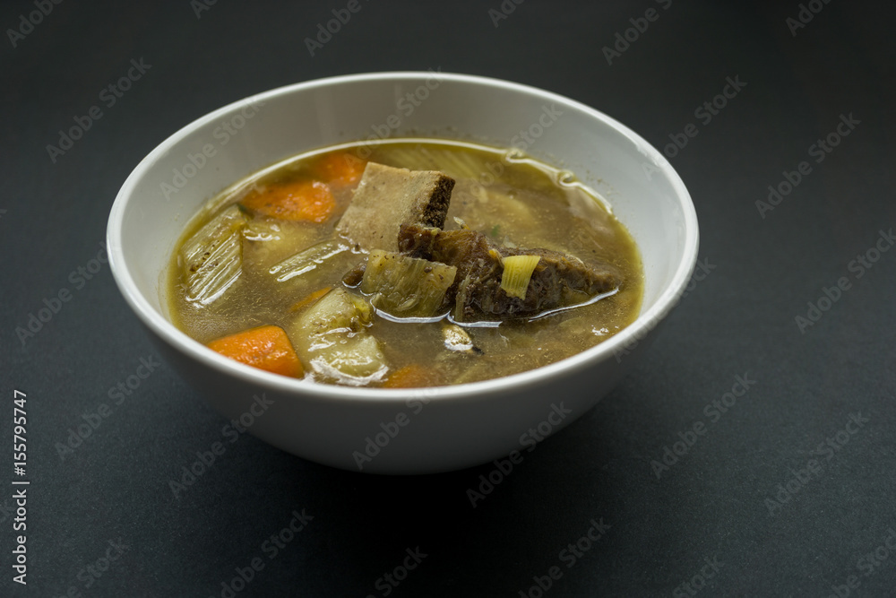 Delicious soup in white bowl over black background. Delicious soup in white bowl over black background.