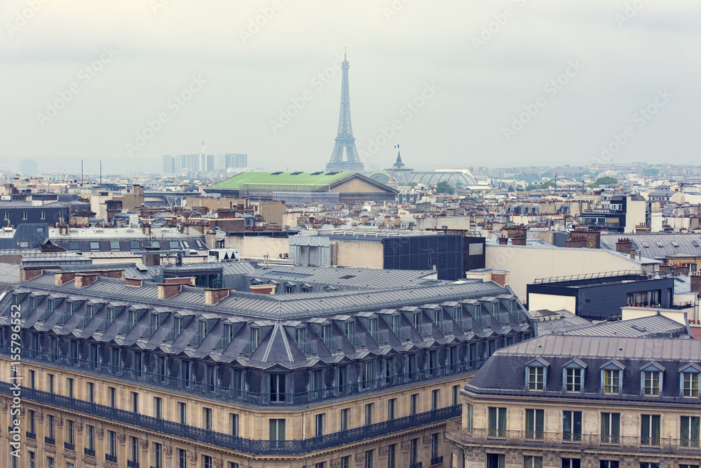 Panoramic view of Paris and Eiffel tower from the top of roof during a gray rainy day, France