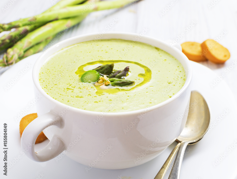 Asparagus cream soup with olive oil in white bowl Asparagus cream soup with olive oil in white bowl