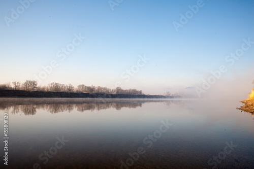 A misty dawn on the river in the early morning in the village