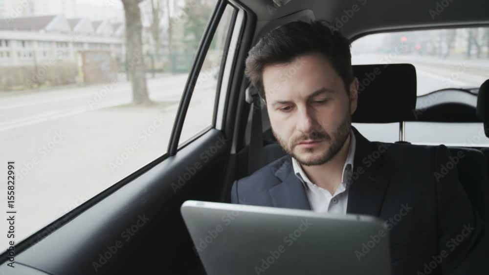 Young Businessman Using a Tablet Computer. The Car Stops
