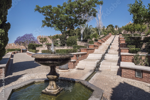 Medieval moorish fortress Alcazaba in Almeria, Access to the Alcazaba with gardens and trees of different species, fountain and stairs of entry lead water along, take in Almeria, Andalusia, Spain