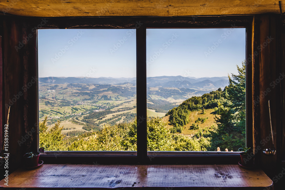 Fototapeta Pole lato i góry widoczne przez okno
