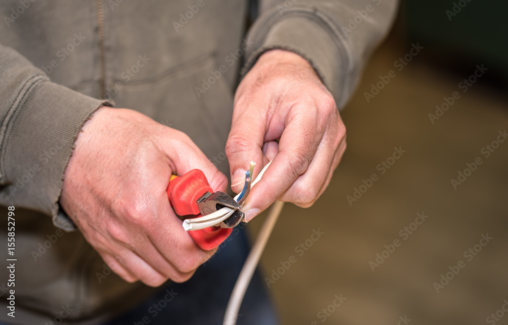 Worker cutting wire with pliers