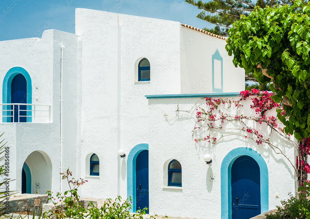 Greek architecture - white buildings, sea and blue windows, Bougainvillea on the white wall