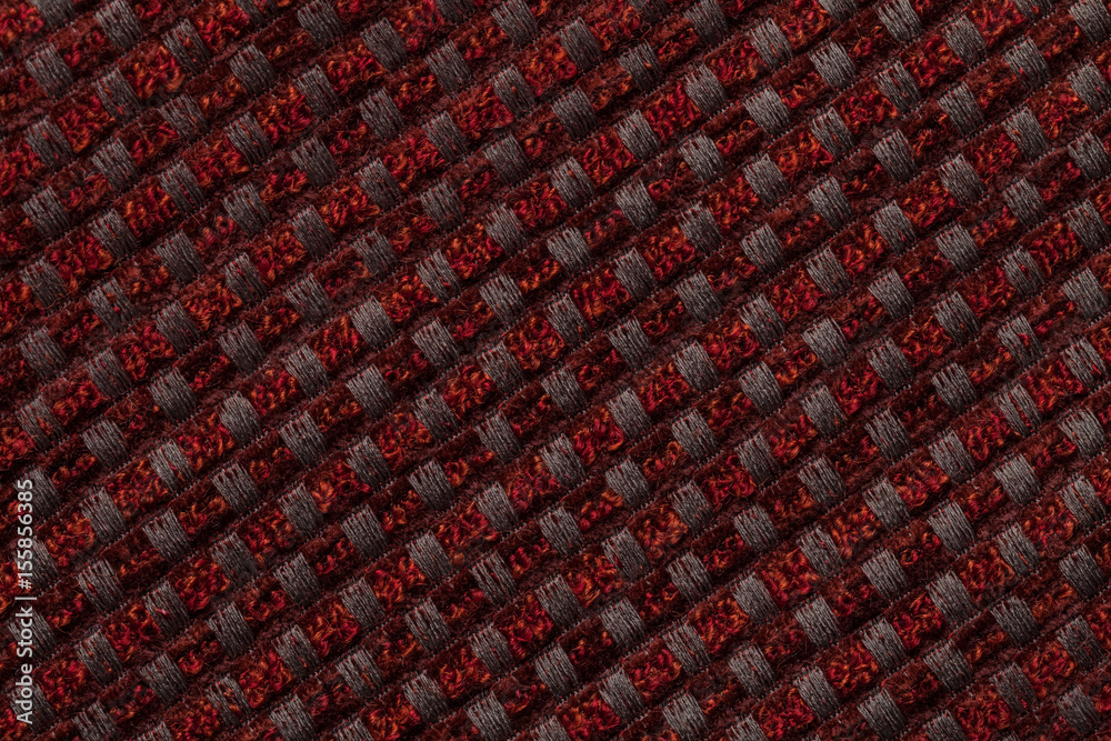 Dark red background from checkered pattern textile, closeup. Structure of the wicker fabric macro.