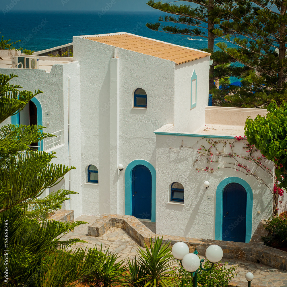 Greek architecture - white buildings, sea and blue windows, Bougainvillea on the white wall