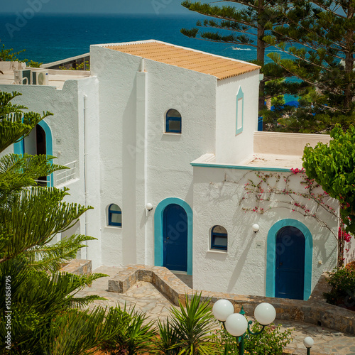 Obraz na płótnie Greek architecture - white buildings, sea and blue windows, Bougainvillea on the white wall w salonie