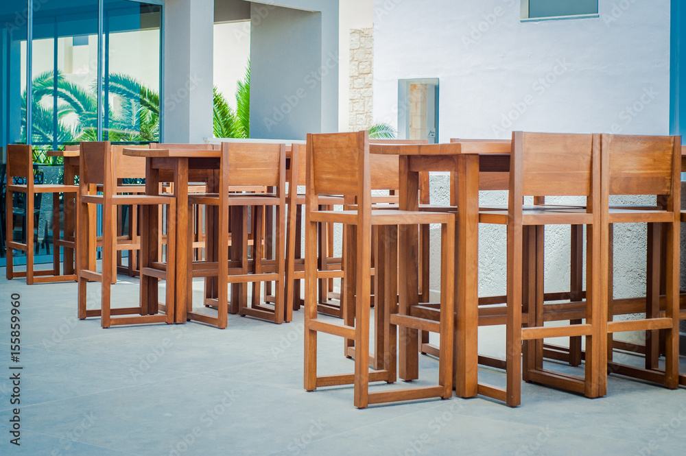 Wooden tables and chairs in seaside Greek restaurant