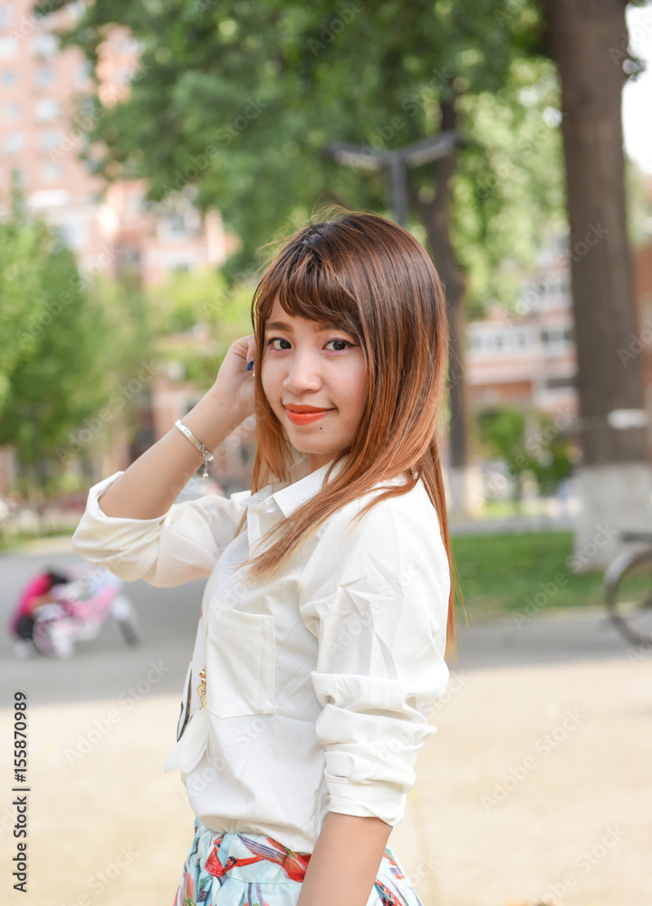 Young woman smiling and looking at camera in campus. Young woman smiling and looking at camera in campus.