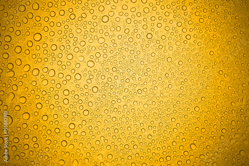 Water drops on yellow glass, Rain droplets on glass background.