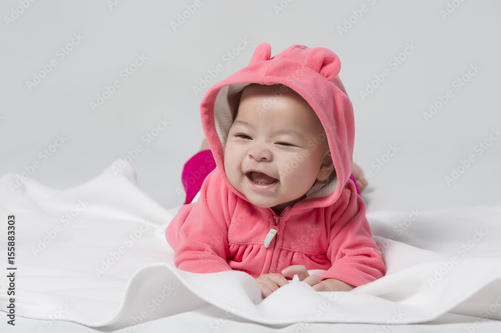 A beautiful Asian baby girl laughing on white background A beautiful Asian baby girl laughing on white background