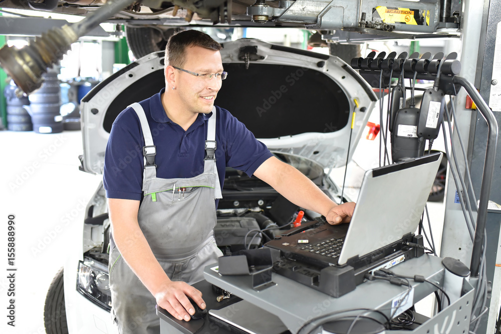 moderne Fehlersuche mit in einer Autowerkstatt KFZ Mechaniker repariert
