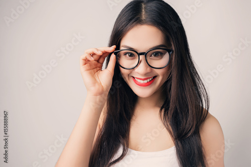Young beautiful Asian woman with smiley face wearing glasses.