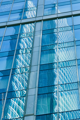 Reflection in blue glass wall of modern office building. Tint blue