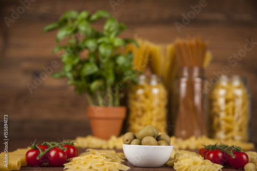 Dry pasta with ingredients on a old wood