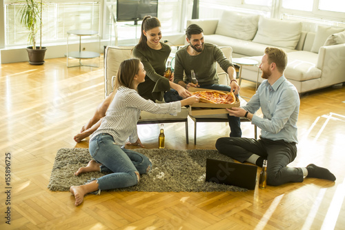 Young people eating pizza a...
