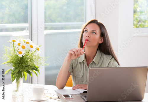 Woman daydreaming at office desk