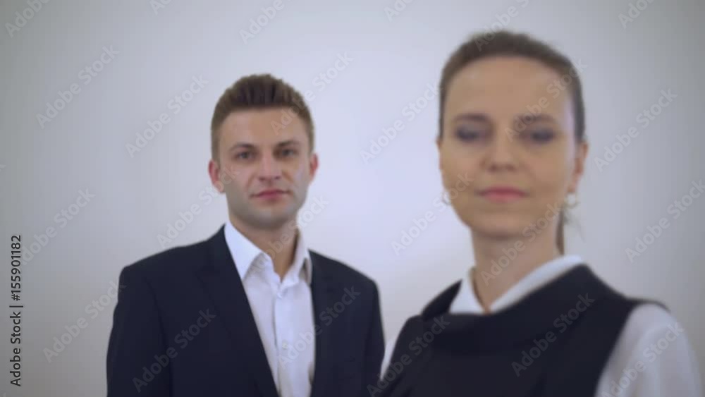 portrait business partners posing looking at the camera. Adult businessman and businesswoman wearing formal clothing white and black color. Focus defocus. portrait business partners posing looking at the camera. Adult businessman and businesswoman wearing formal clothing white and black color. Focus defocus.