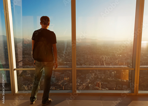 Man looking over the big city from the viewpoint at sunset time. © Diana Vyshniakova