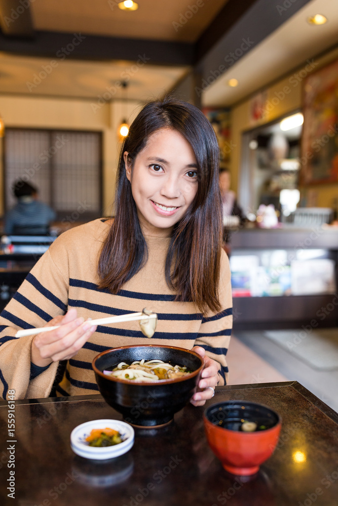 Woman eating udon in japanese restaurant