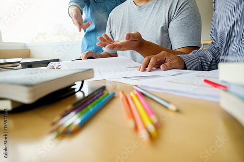 Education concept. Students studying and brainstorming campus concept. Close up of students discussing their subject on books textbooks and writing to notebook. Selective focus.