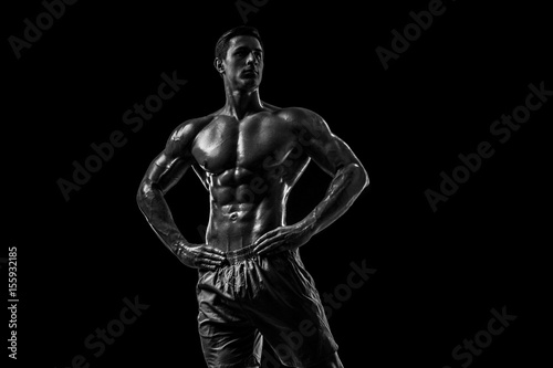 Muscular and fit young bodybuilder fitness male model posing ove