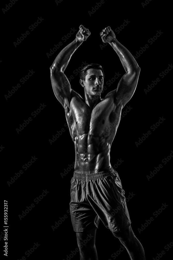 Muscular and fit young bodybuilder fitness male model posing ove