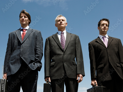 Three Businessmen standing side by side. photo