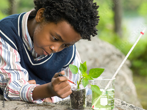 A boy doing an experiment on a plant