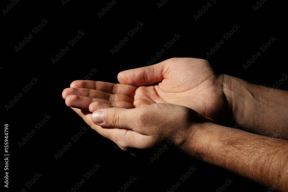 Male hands on a black background