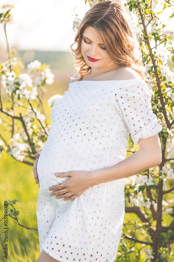 Happy pregnant woman in white blossom garden Happy pregnant woman in white blossom garden