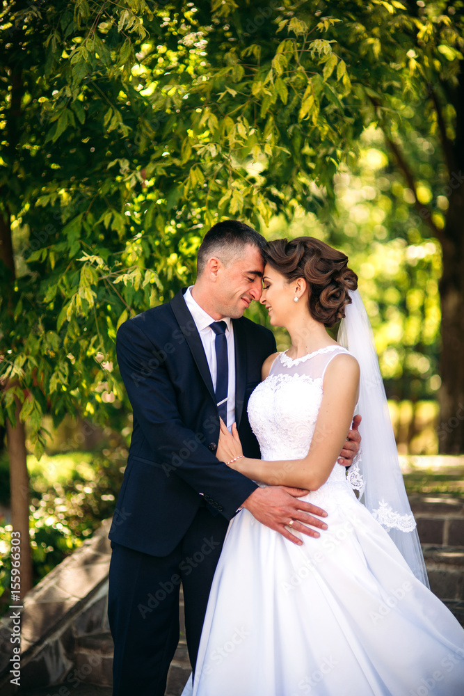 Young couple, bride and groom walking and enjoying their wedding day. Sunshine. Summer. Young couple, bride and groom walking and enjoying their wedding day. Sunshine. Summer.