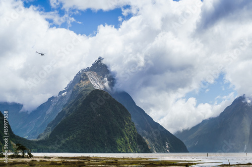 Helicopter flying past the giant Mitre Peak mountain of the Milford Sound photo