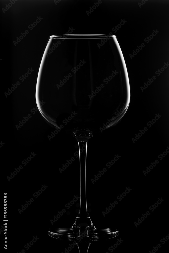 Transparent glass for wine on a black background. Transparent glass for wine on a black background.