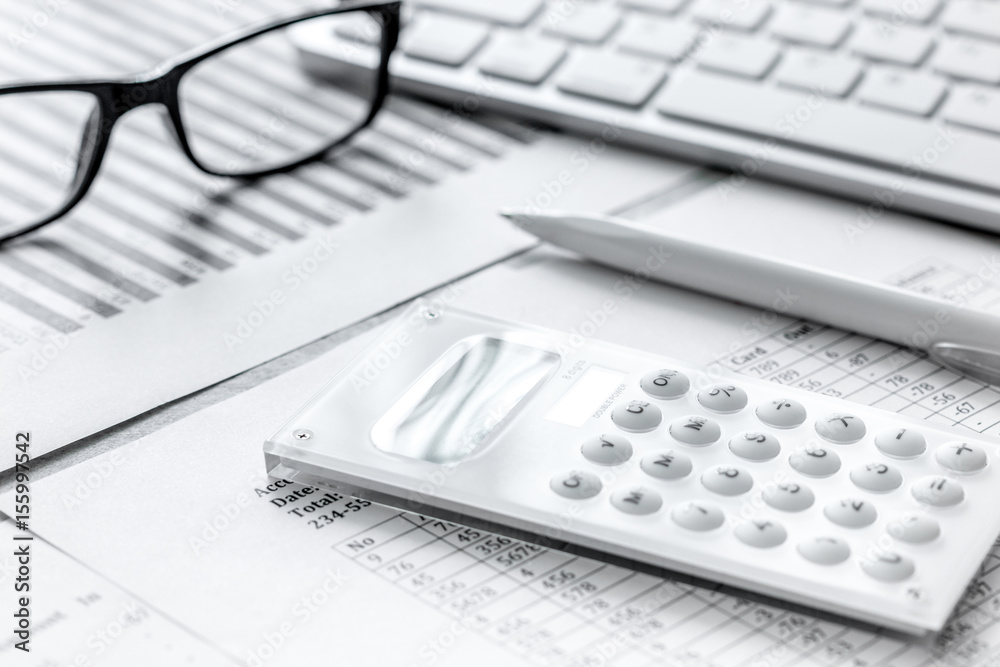 Business report preparing with calculator and glasses on office background Business report preparing with calculator and glasses on office background