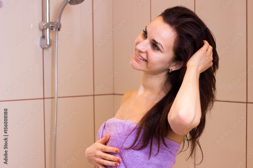 Young woman in towel in bathroom 