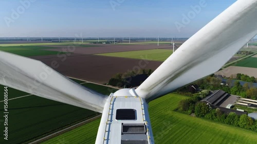 Aerial of wind turbine bird view stable flight looking down and moving higer and panning camera down beautiful view of aerofoil powered windmills providing sustainable energy renewable energy 4k photo