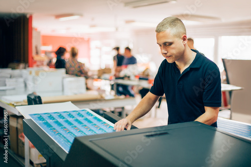 Young man working in printing factory