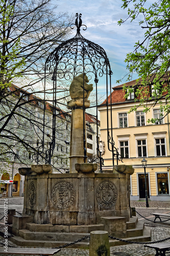 Fountain with a sculpture of a bear, symbol of Berlin, in Nikolaikirchplatz (Nicholas square) in Berlin, Germany photo