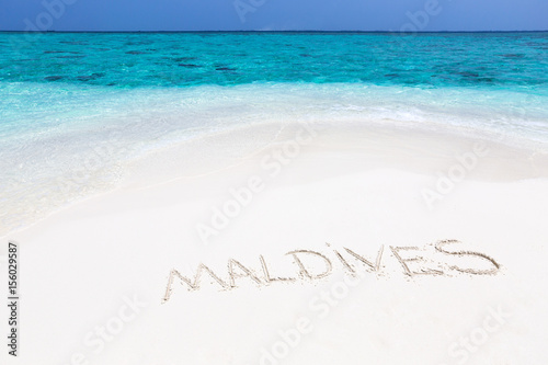 Handwriting word "Maldives" on maldivian beach