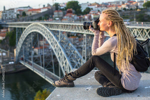 Young woman takes photographs of Dom Luis I bridge, Porto, Portugal. © De Visu