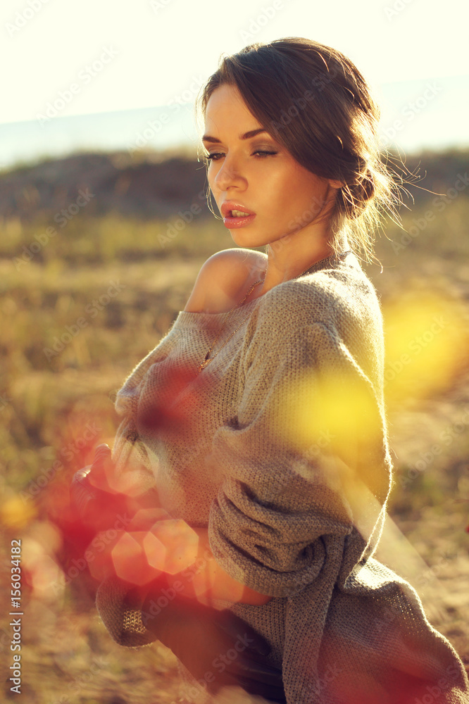 Obraz premium young pretty woman standing in autumn yellow colours field and dreaming with closed eyes. beautiful portraits made with backlit