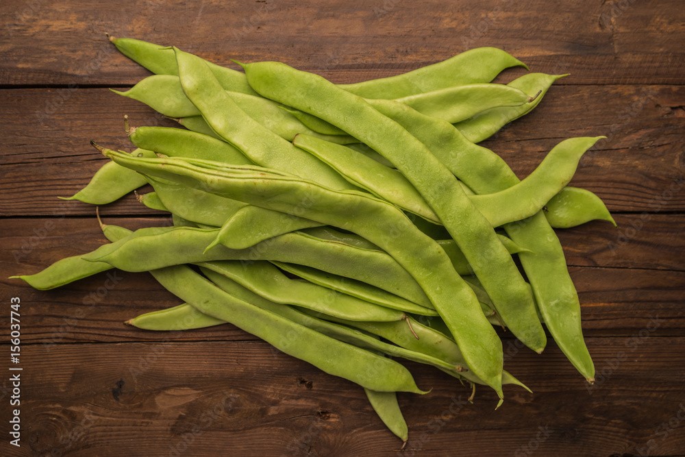 A pile of fresh green beans on table. Green runner beans. Top view