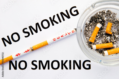 No Smoking - with cigarettes and ashtray with printed words on blue and white background

