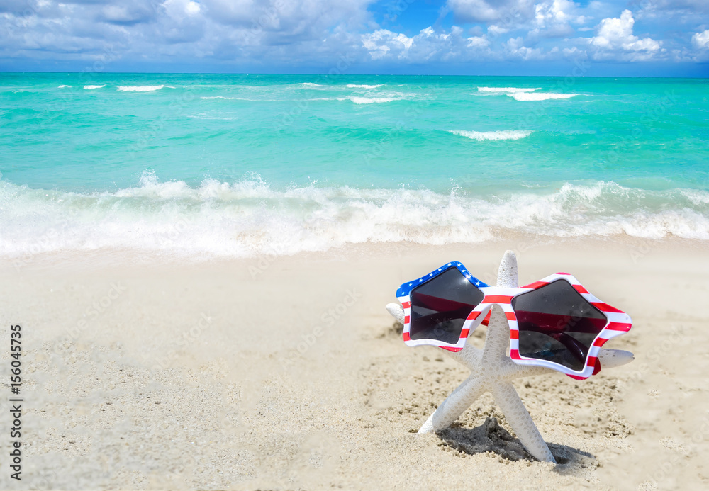 Naklejka premium Patriotic USA background with starfish on the sandy beach
