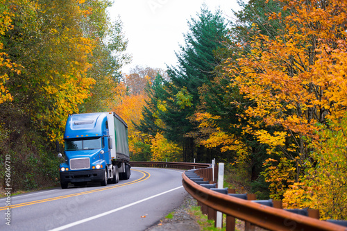 Blue semi truck on winding highway in autumn Columbia Gorge