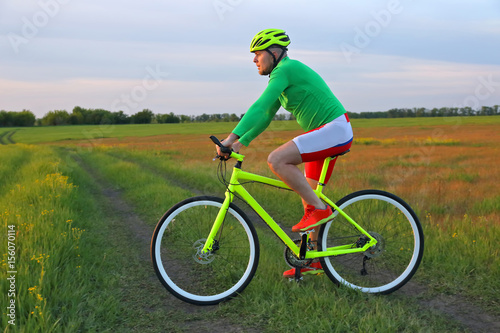 cyclist rides a bicycle in a field